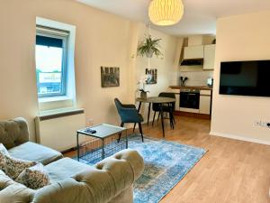 a living room with a couch and a table at Stylish spacious 1 bed flat in Shilton
