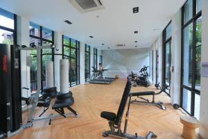 - une salle de sport avec des tapis de course et des vélos d'exercice dans une pièce dotée de fenêtres dans l'établissement Saturdays by Holy Cow, à Ban Saiyuan (1)