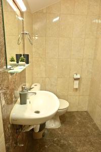 a bathroom with a white sink and a toilet at Coastalguest House in Veliko Tŭrnovo