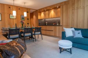 a living room with a blue couch and a table at Borgo PLAZA CHALET in Bormio