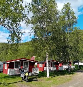 a row of red cottages with a motorcycle parked in front at Nordnes Kro og Camping in Rokland