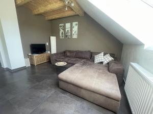 a living room with a couch and a tv at Ferienwohnungen Fischbachhof in Sulzbach an der Murr