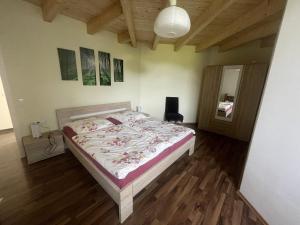 a bedroom with a bed and a wooden floor at Ferienwohnungen Fischbachhof in Sulzbach an der Murr