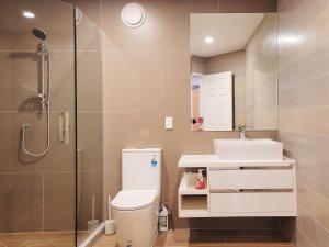 a bathroom with a shower and a toilet and a sink at Sea view 5 bedroom holiday house in Whangaparaoa +26 photos