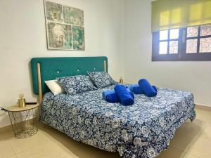une chambre avec un lit avec des oreillers bleus dessus dans l'établissement Sunny Apartment, à Puerto del Carmen 26 autres photos