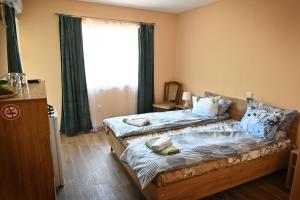 a bedroom with two beds and a window at Coastalguest House in Veliko Tŭrnovo