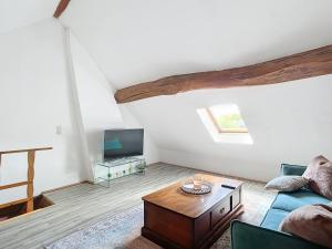 ein Wohnzimmer mit Sofa und Fernseher in der Unterkunft Charmante maison in Joux-la-Ville