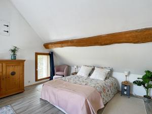 ein Schlafzimmer mit einem Bett und einem Stuhl in der Unterkunft Charmante maison in Joux-la-Ville
