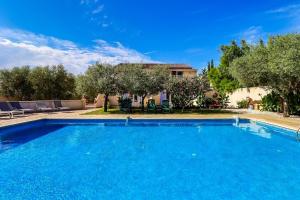 a large blue swimming pool in front of a house at Le Beaucaire 4P - Appt 4p climatisé avec piscine in Beaucaire +9 photos