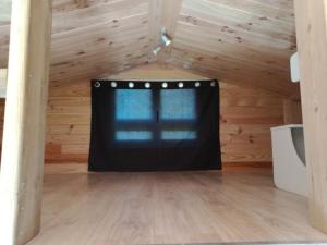 a room with a window in a wooden house at chalet tout confort in Coullons