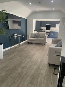 a living room with two couches and a kitchen at The Old Stable, Rustic Charm Modern Comforts in Gorfield