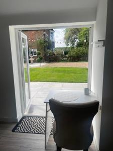 a table and a chair in front of a door at The Old Stable, Rustic Charm Modern Comforts in Gorfield
