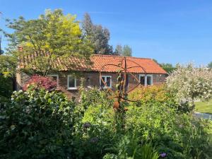 a brick house with a garden in front of it at The Old Stable, Rustic Charm Modern Comforts in Gorfield