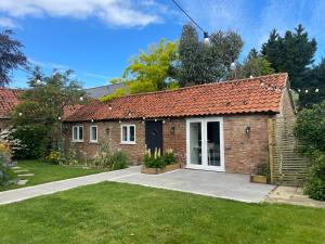 a brick house with a white door at The Old Stable, Rustic Charm Modern Comforts in Gorfield