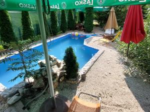 a swimming pool in a yard with an umbrella at Apartments Daut's Tower in Sarajevo +45 photos