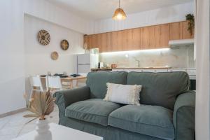 a living room with a green couch and a kitchen at Valia's Place in Tsoutsouros
