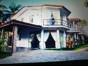 a house with a dog standing in front of it at Hotel Friendstar in Minuwangoda +13 photos