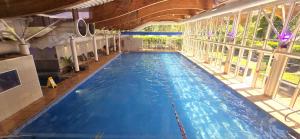 a large swimming pool with blue water in a building at Manor Of Groves Hotel, Golf & Health Club in Sawbridgeworth