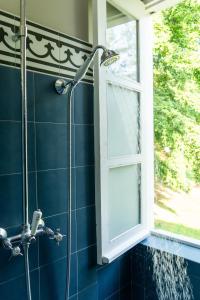 a shower in a blue bathroom with a window at Roça Sundy - Principe Collection in Santo António