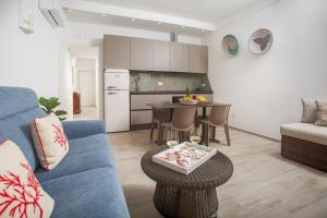 a living room with a blue couch and a table at TrèSOR in Santa Teresa Gallura +45 photos