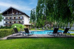 un gruppo di sedie a sdraio accanto alla piscina di Finkensteiner Hof a Finkenstein am Faaker See