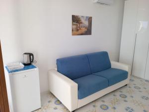 a blue couch in a room with a painting at L’Oasi del Barone in Villammare
