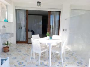 a white table and chairs on a patio at L’Oasi del Barone in Villammare