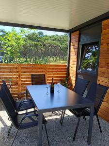 a table with two chairs and a bottle of wine at Camping Planik in Ražanac