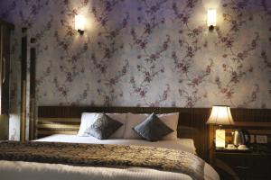 a bedroom with a bed with a floral wallpaper at Hote Meghnath Palace in Dhupguri