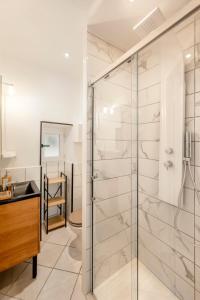 a bathroom with a glass shower and a sink at Urban Jungle PARKING & Netflix Centre historique in Manosque +7 photos