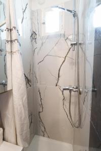 W łazience znajduje się prysznic z marmurową zasłoną prysznicową. w obiekcie Le Marais cosy-comfy appartment w Paryżu