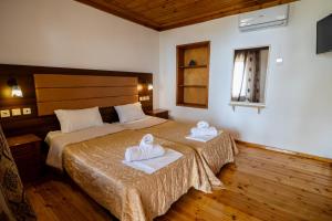 a bedroom with a bed with two towels on it at Hotel Kokkino Nero in Kókkinon Nerón