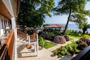 a balcony of a house with flowers and a gazebo at Hotel Kokkino Nero in Kókkinon Nerón