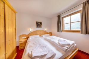 une chambre avec un grand lit avec des serviettes dessus dans l'établissement Schöneben Chalet Enzian, à Wald im Pinzgau 37 autres photos