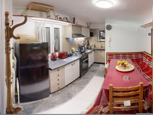 a kitchen with a red table and a black refrigerator at Rooftop Loft with Hydromassage in Volos