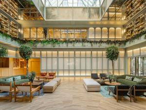a lobby with couches and tables in a building at Only YOU Hotel Sevilla in Seville