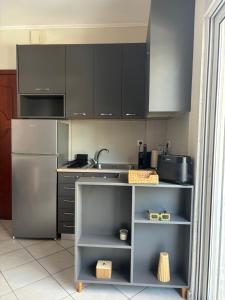 a kitchen with black cabinets and a stainless steel refrigerator at Blooming 31 AXD in Alexandroupoli