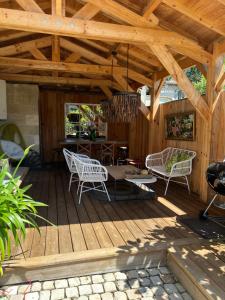 a wooden deck with chairs and a table on it at La Maison Mulatô, appartement de charme, Libourne - Saint Emilion in Libourne +8 photos
