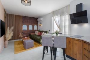 a kitchen and living room with a green couch at Apartment Belvedere by SeeAdria Agency in Novigrad Istria