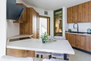 a kitchen with a white counter top and wooden cabinets at Apartment Belvedere by SeeAdria Agency in Novigrad Istria +14 photos