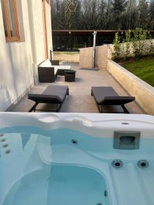 a jacuzzi tub with two chairs and a patio at Green Woods in Verona