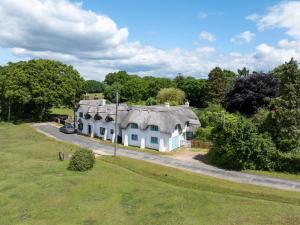 une vue aérienne d'une maison avec un toit de chaume dans l'établissement Forest Cottage, à Lymington
