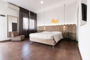 a bedroom with a large bed and a chair at Villa Liliana in Cervia
