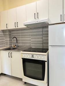 a kitchen with a stove and white cabinets at Central Prestige Apartment in Budva
