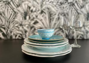 a stack of plates with a blue bowl on top at Akasti Slow Living in Paralia Sikias