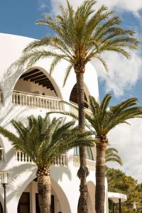 two palm trees in front of a building at Hilton Mallorca Galatzo in Paguera