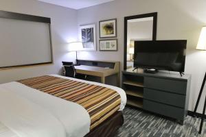 a hotel room with a bed and a flat screen tv at Country Inn & Suites by Radisson, Sparta, WI in Sparta