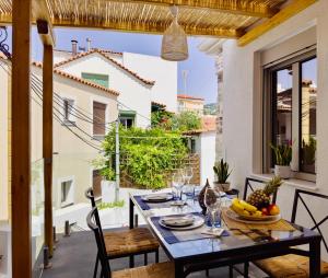 a dining table on a balcony with a view of a building at Kefi House Skiathos in Skiathos