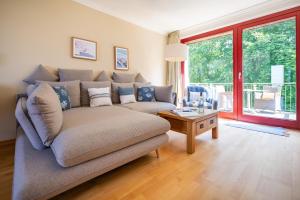 een woonkamer met een bank en een tafel bij Eagle mit Ostseeblick - Haus Fore zu Schloss Ranzow in Lohme