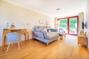 een woonkamer met een bank en een stoel bij Eagle mit Ostseeblick - Haus Fore zu Schloss Ranzow in Lohme +6 foto's